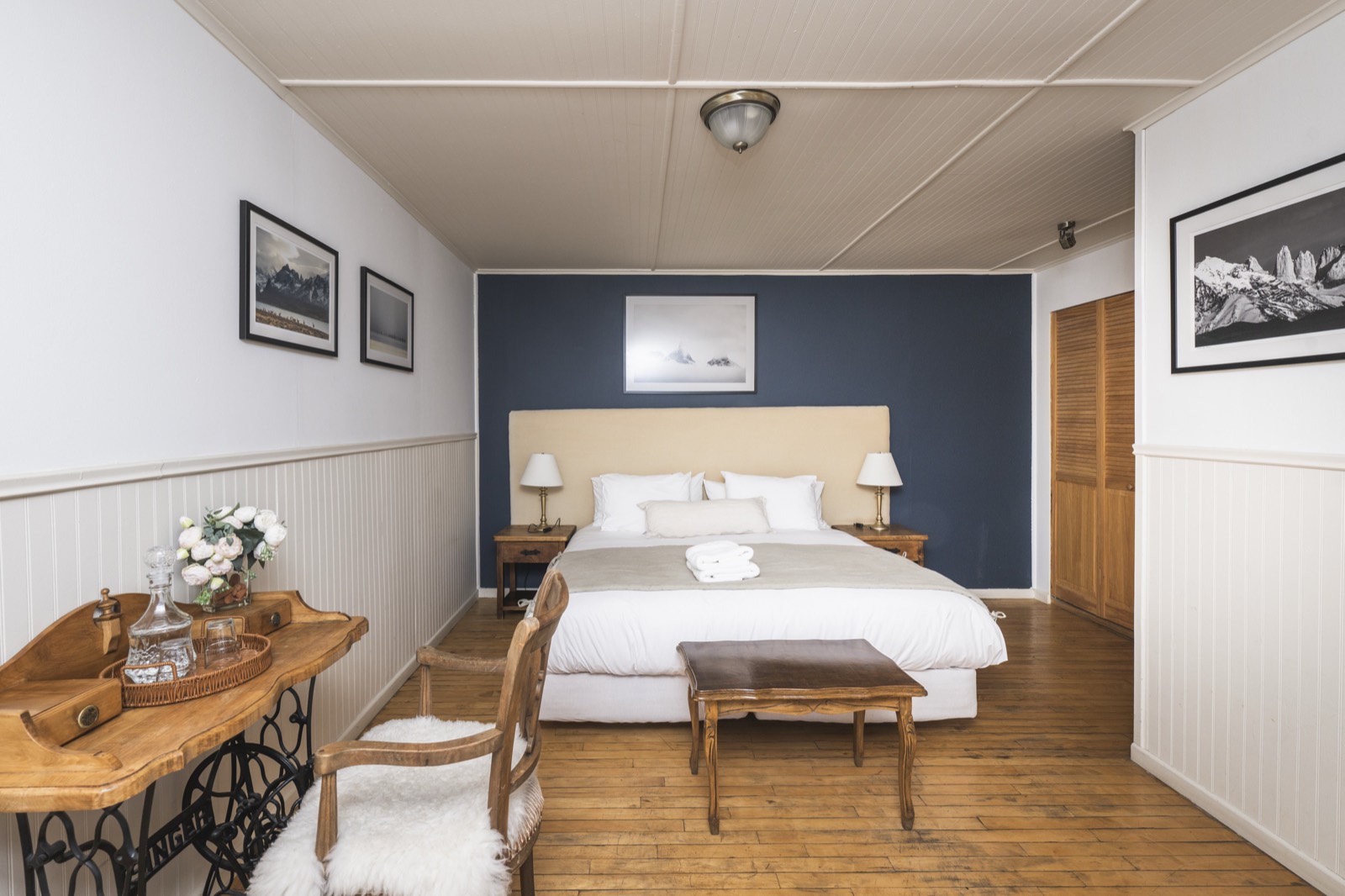 Glaciar room: warm wood, navy accent wall and framed Patagonian photography