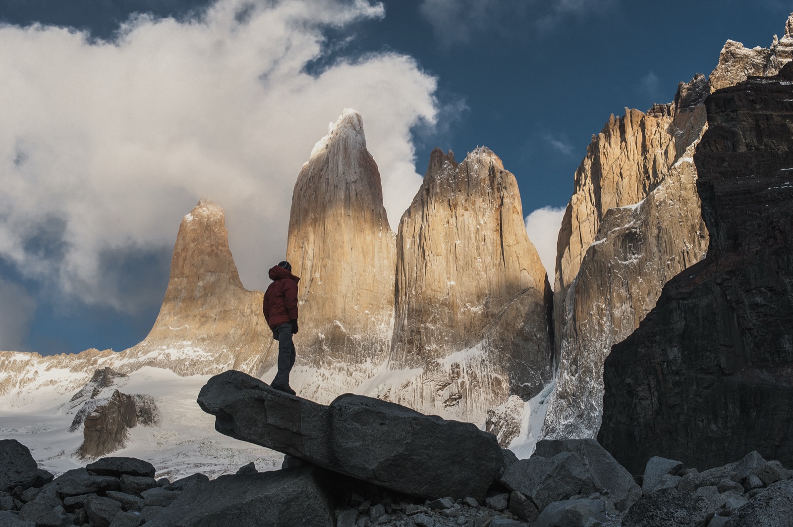 Two hikers at the glacial lagoon below the three granite towers of Torres del Paine