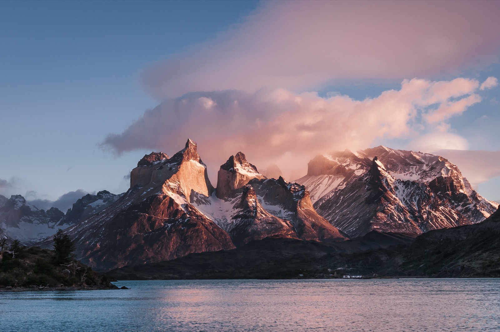 A couple looking out over a turquoise lake to the Cuernos del Paine on a full-day tour