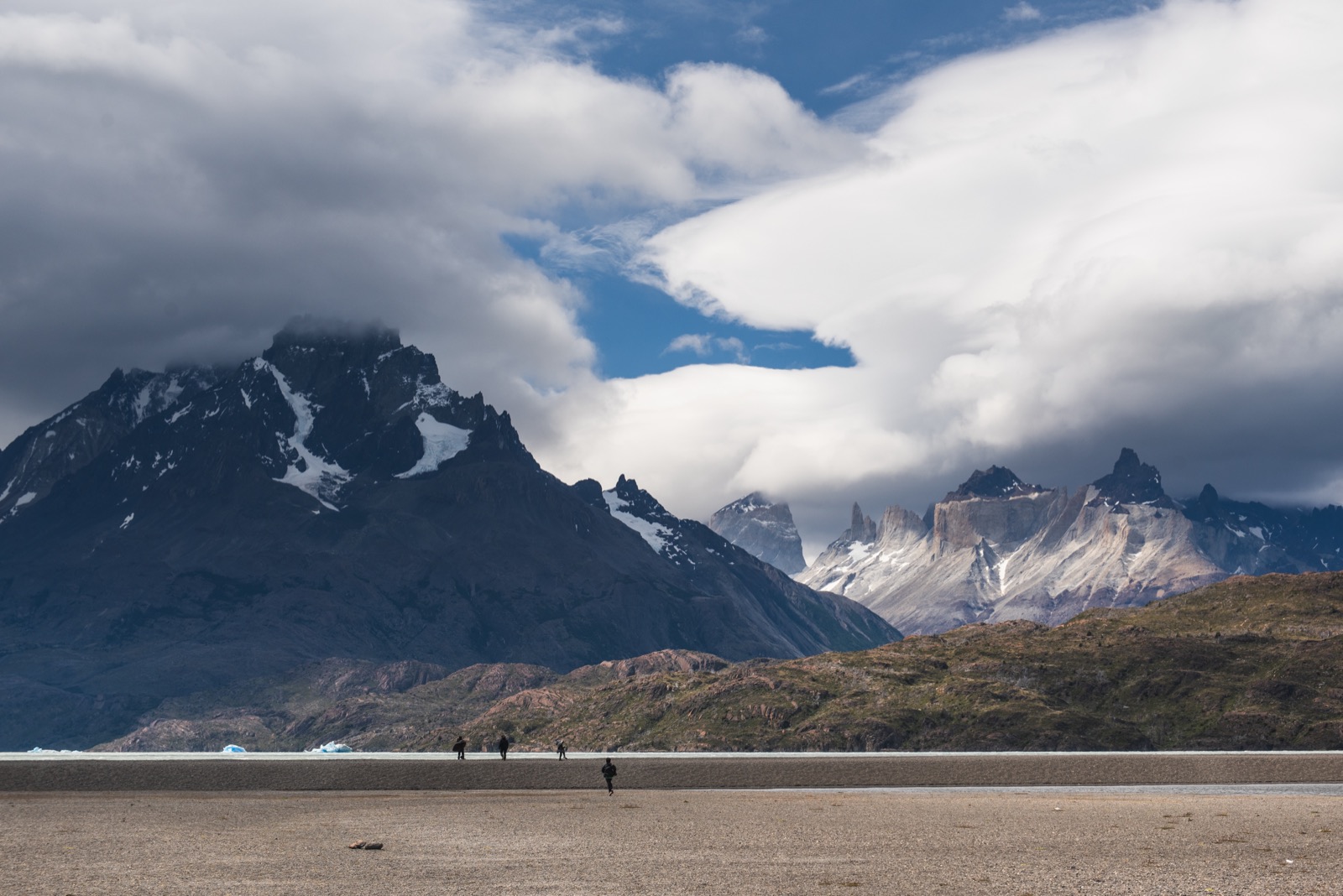 The blue ice wall of Grey Glacier meeting a rocky ridge, seen from the water